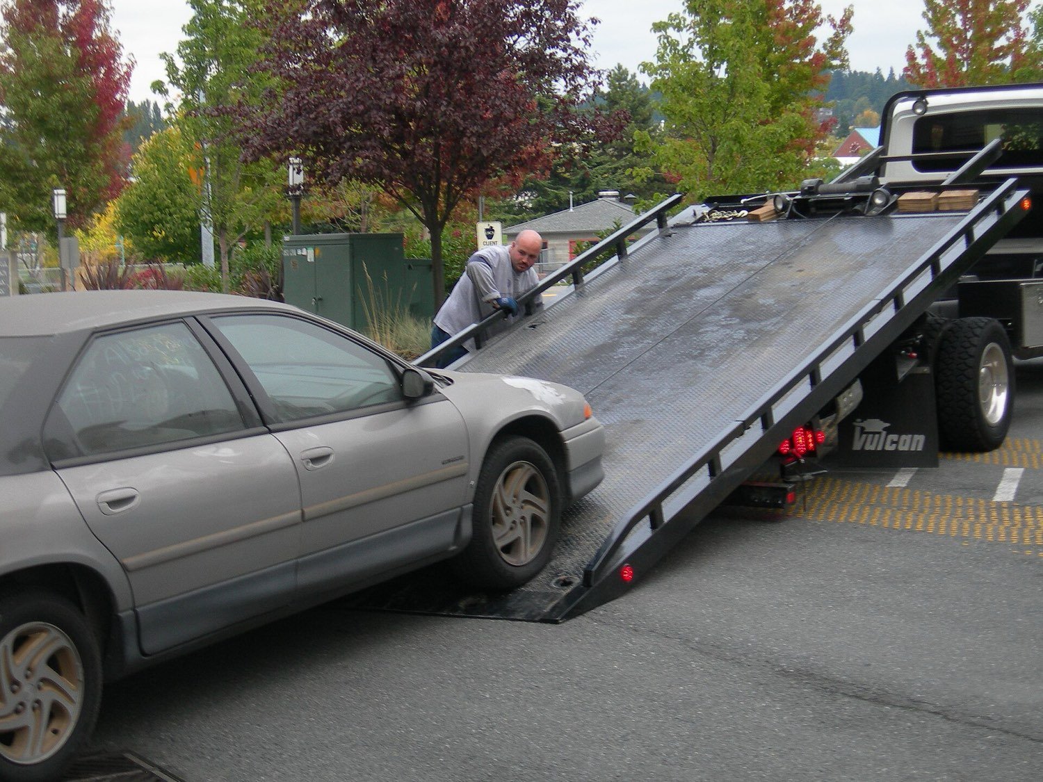 Carro sendo removido sobre a plataforma de um guincho